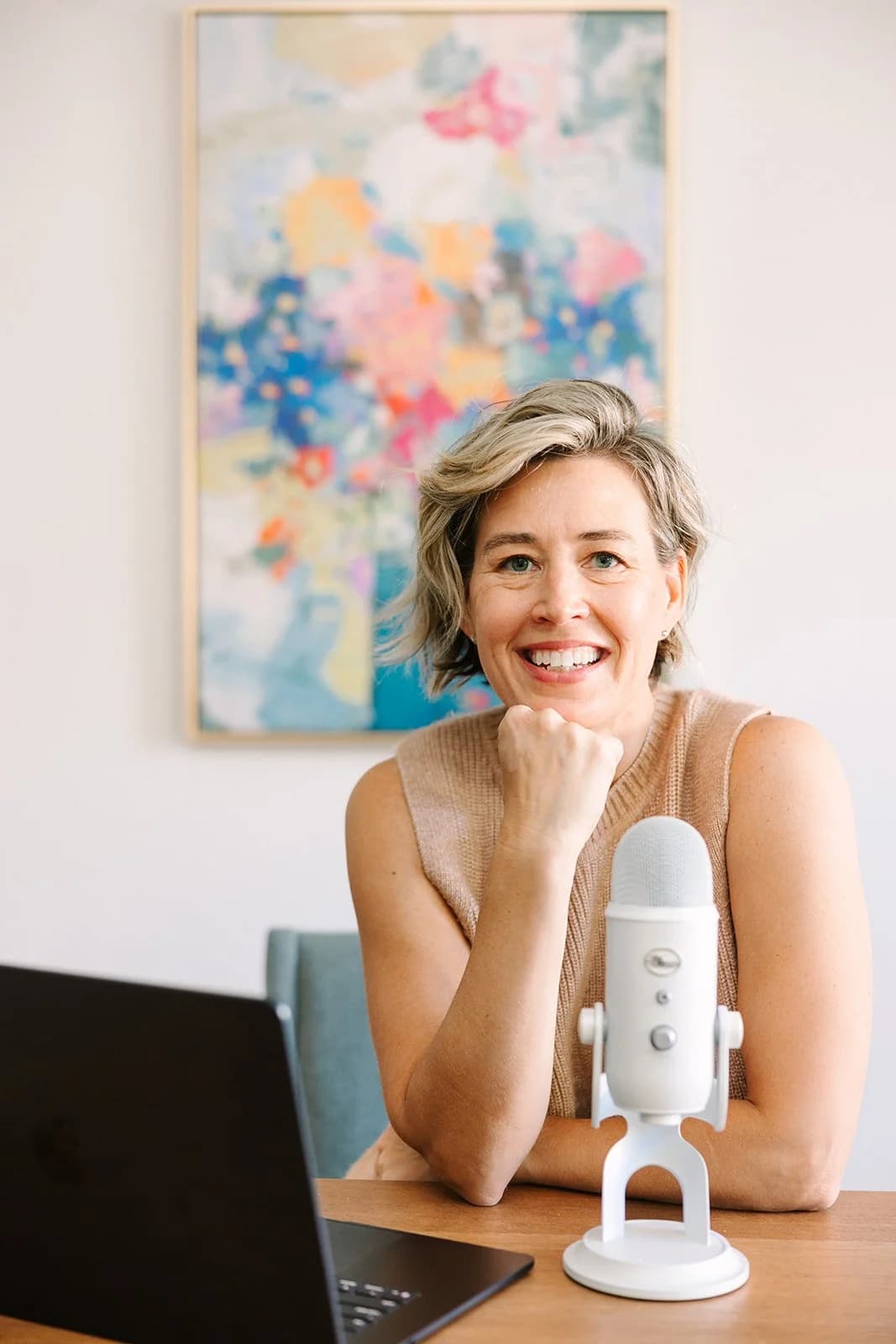 Sarah smiling with a podcast microphone